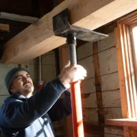 Adjusting structural jack post to support historic timber frame during restoration