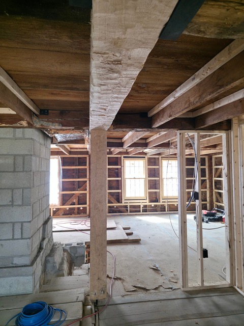 Interior structural framing repairs in historic Oakham Massachusetts home showing exposed timber beams and wall framing