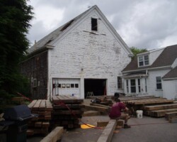 A man is standing in front of a white house.