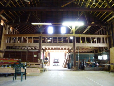 The inside of a barn with wooden beams.