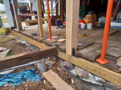 A wooden deck is being built in front of a house.