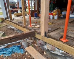 A wooden deck is being built in front of a house.