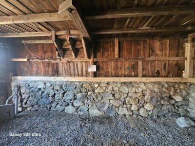 The inside of a barn with stone walls and a stone floor.