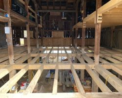 The inside of a barn with wooden beams.